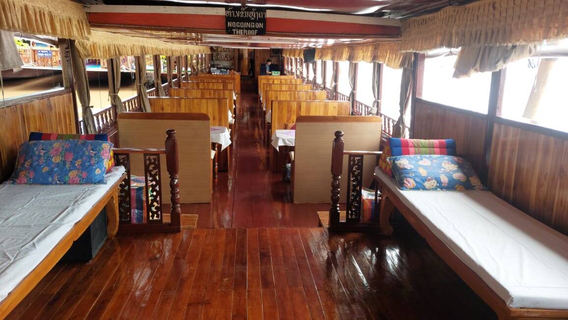 Wooden benches inside a Mekong slow-boat cabin